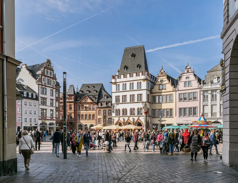Belebter Hauptmarkt in Trier mit bunten Bürgerhäusern und Menschen